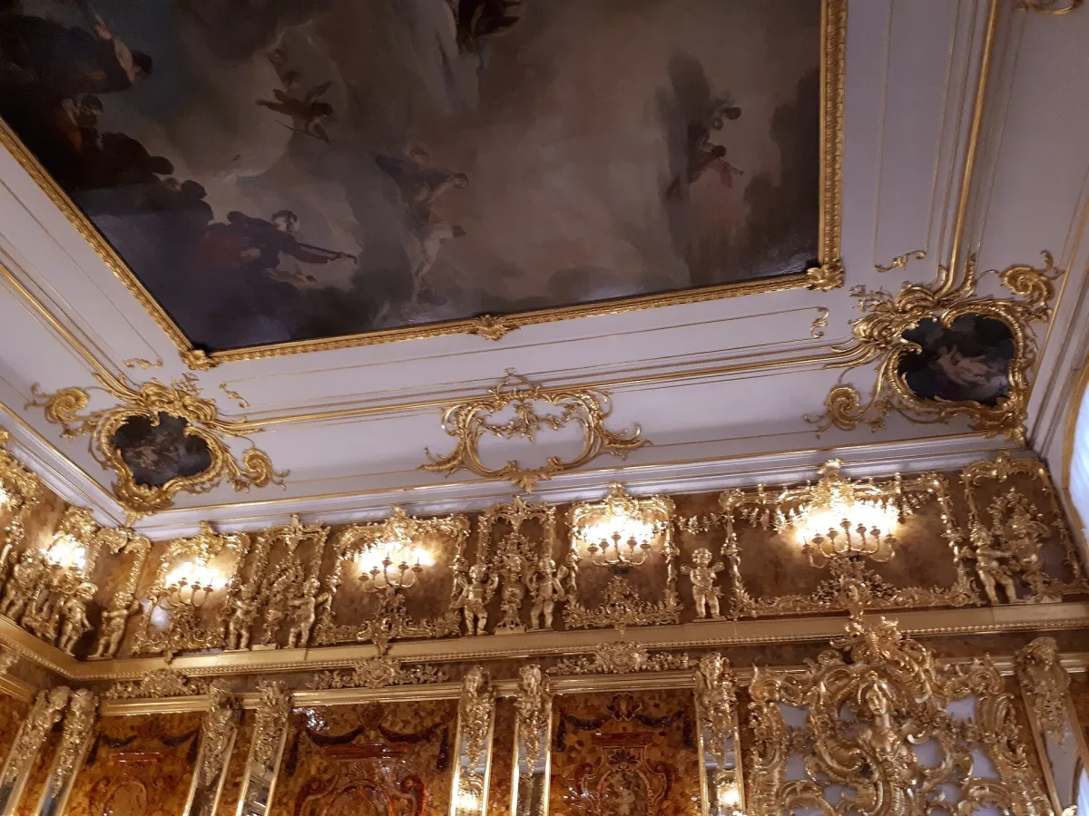 A corner of the Amber Room at the Catherine Palace: walls of honey-coloured amber mosaic panels with gilded carving and mirrors.