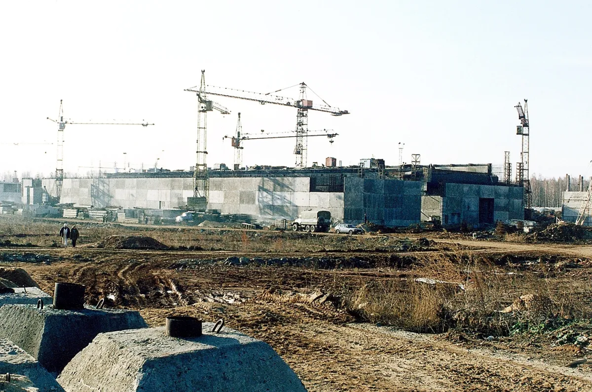 A construction site at the Mayak nuclear complex: part-built concrete structures with tower cranes above them and churned ground in the foreground.