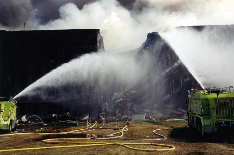 Two engines pouring water onto the smoking collapsed section.