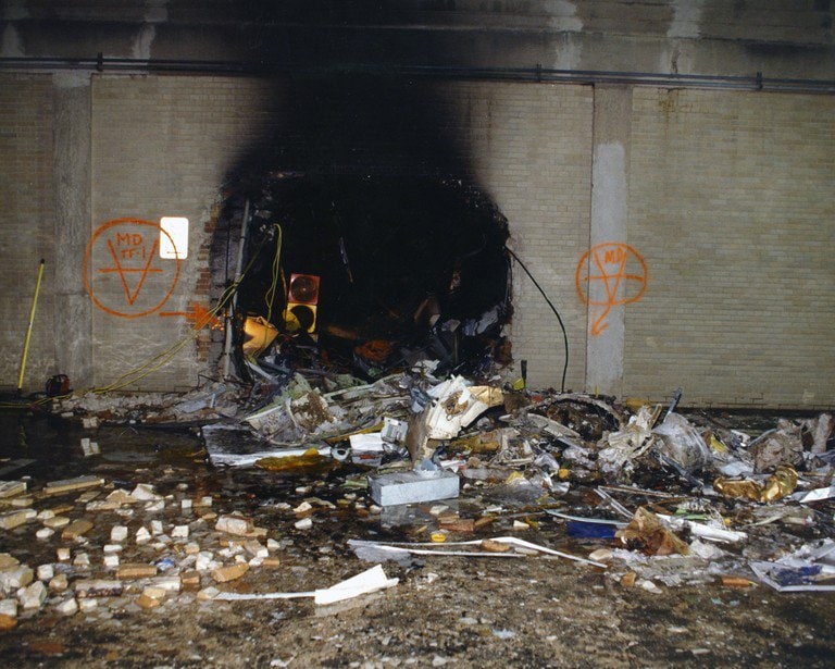 A breach in the exterior wall at ground level, search markings sprayed on the limestone either side.